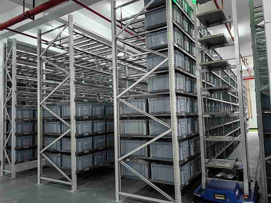 AGV integrating with precision-aligned selective pallet racking for automated storage and retrieval.