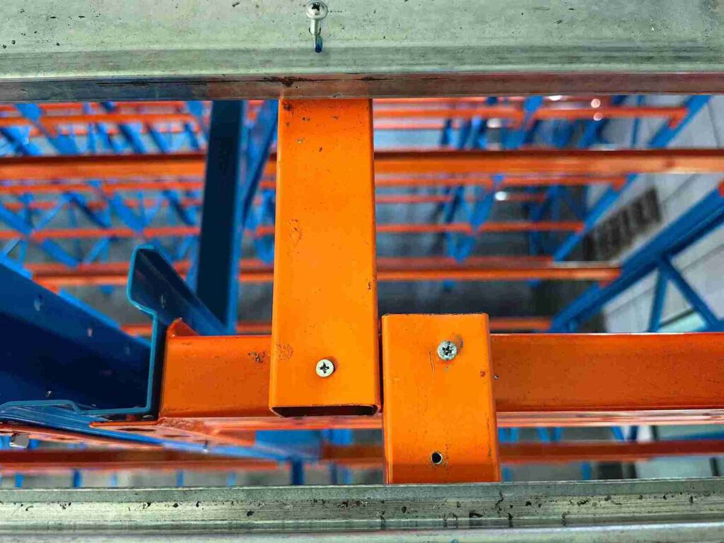  Engineer inspecting beam connectors for beam racking maintenance schedule compliance