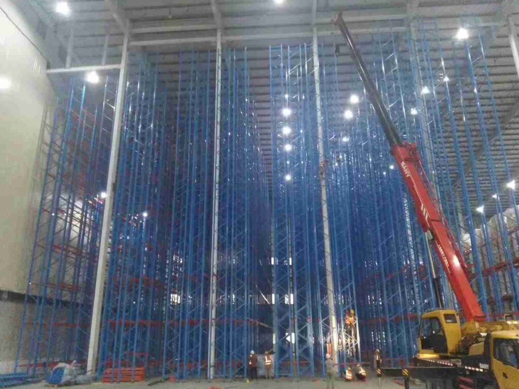 Expert beam racking installation services crew erecting upright frames with precision lifting equipment