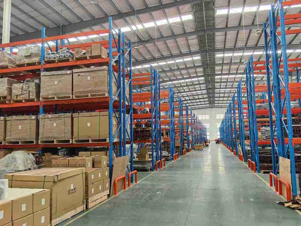 Heavy-duty engineered steel structure of industrial very narrow aisle pallet racking system with safety guards.