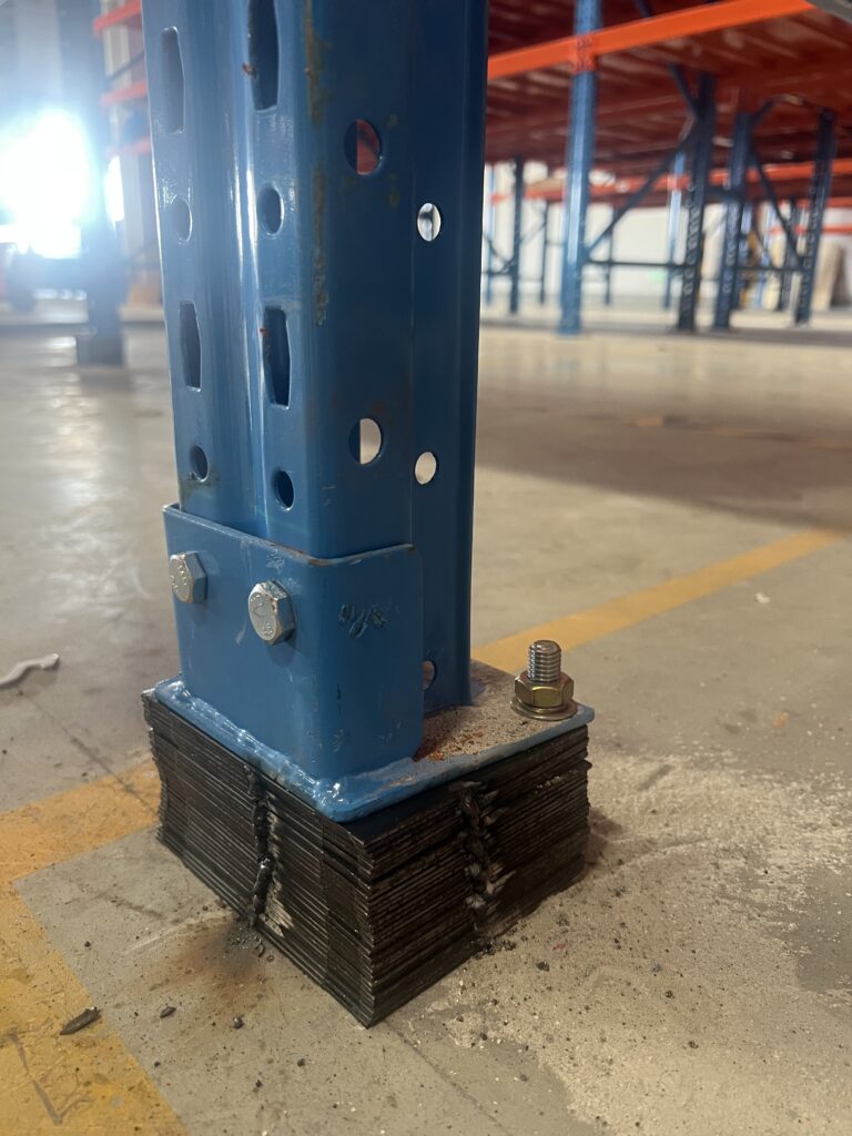 Steel shim stack installation for beam racking leveling techniques showing proper baseplate contact