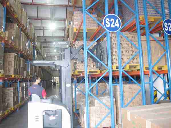 Technical illustration of forklift operation within a double deep pallet racking system.