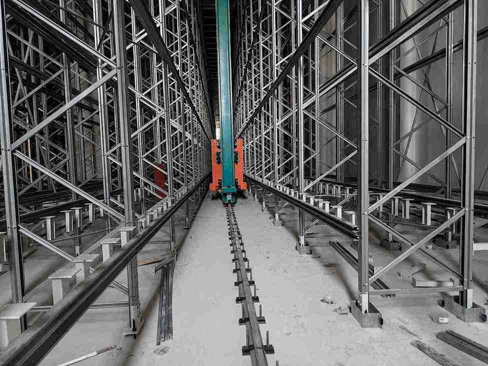 Turret truck operating efficiently in a guided very narrow aisle pallet racking channel for high-level storage.