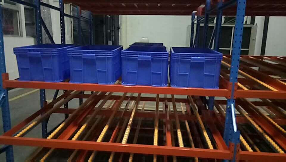 Warehouse worker using carton flow racking for fast order picking